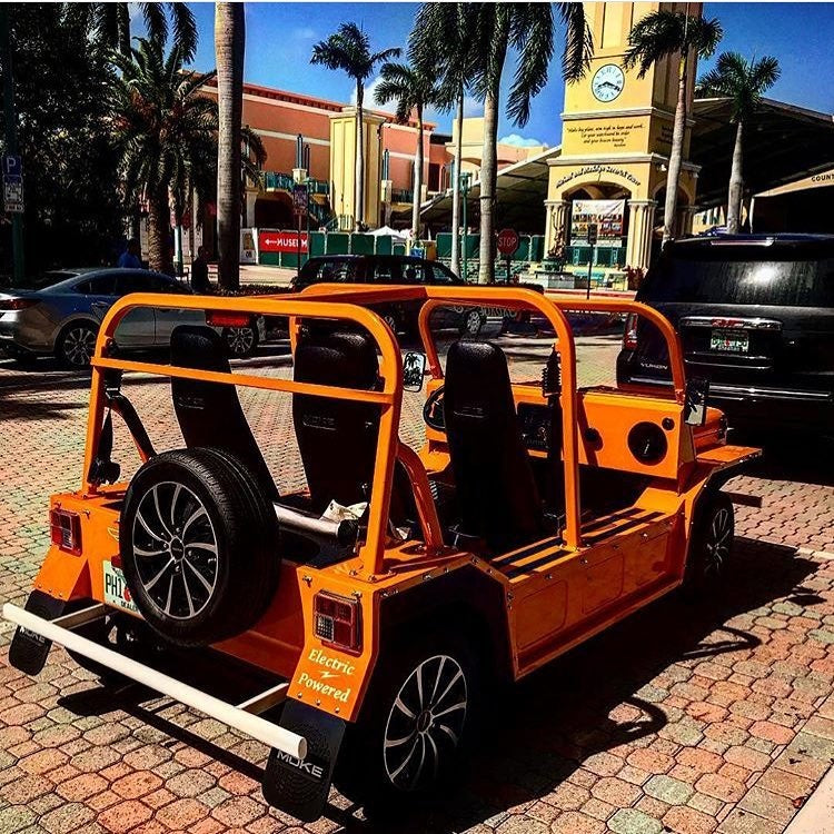 An orange Moke parked on a brick street in Boca Raton