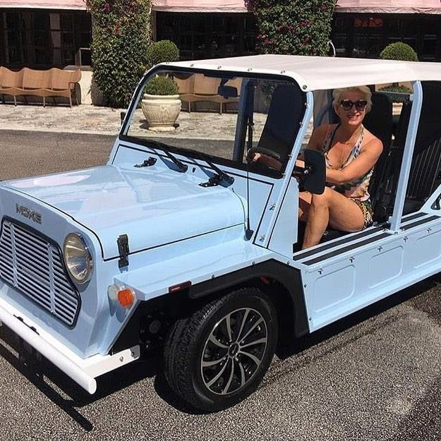 A woman seated in a white Moke in Boca Raton