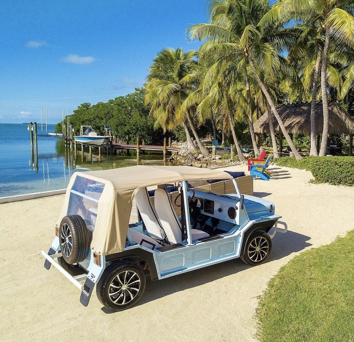 A light blue Moke parked on the sand beside the water in Islamorada