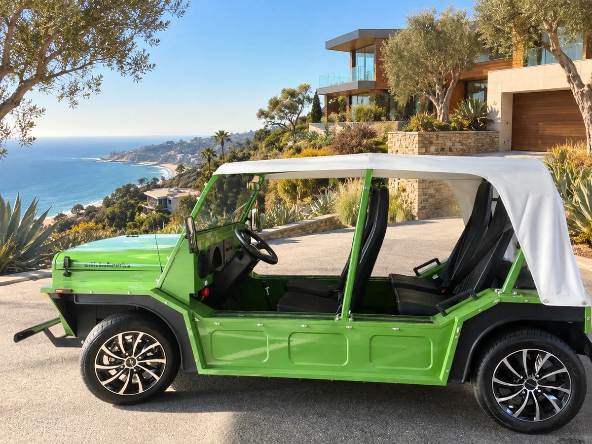 A green Moke on a drive beside a Malibu hillside house above the ocean
