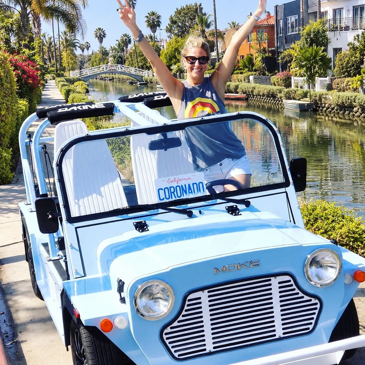 A light blue Moke beside a Venice canal footbridge